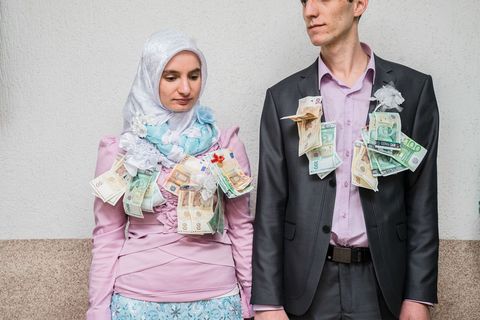 Pasgetrouwden Salve Kgiselova links en Reihan Kiselov dragen een deel van het geld dat aan hen was gegevens als huwelijkscadeau