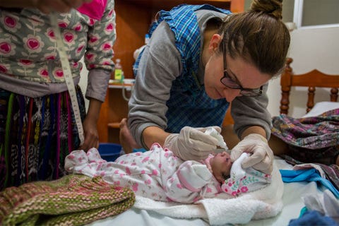Verloskundige Mallory Betz smeert antibioticazalf op het pasgeboren kind van Gladys Sanchez Cabrera Betz leidt verloskundigen op en is assistentprojectcordinator bij de ACAM