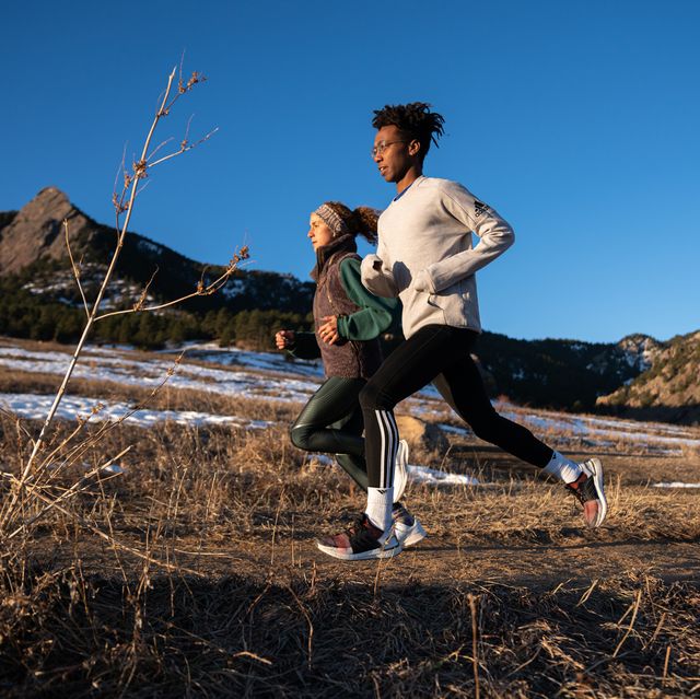 two runners on a mountain trail in winter