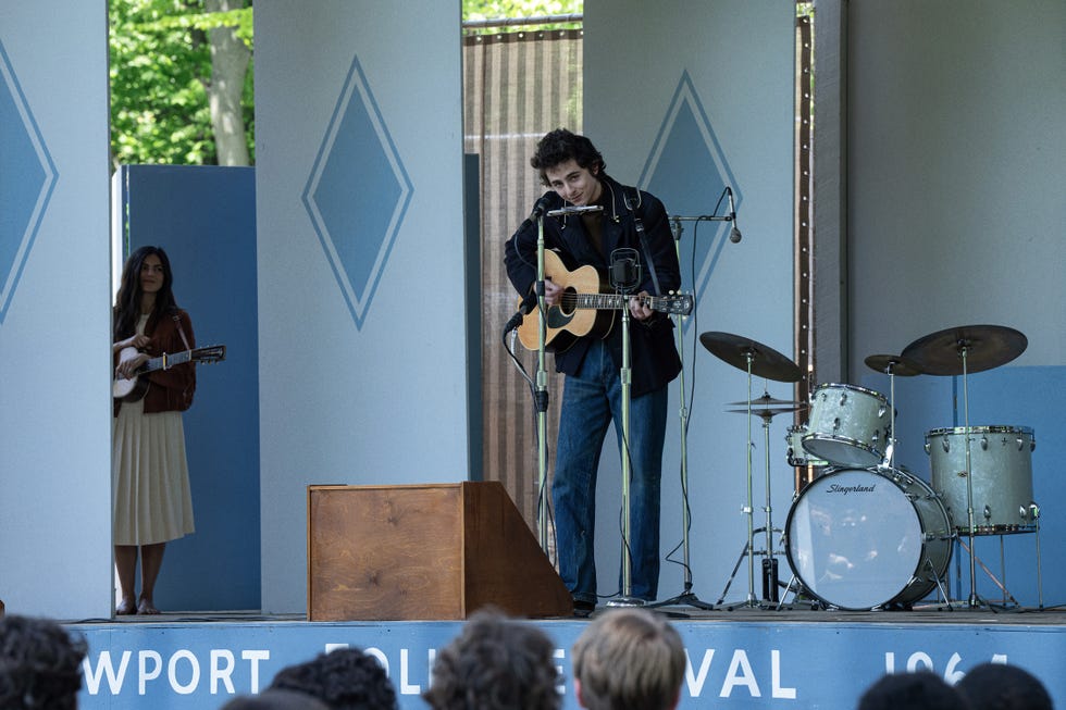 musicians performing on a stage with drums and audience