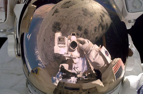 Tijdens historisch reparatiewerk aan het hitteschild aan de onderzijde van de spaceshuttle Discovery op 3 augustus 2008 richtte astronaut Steve Robinson de camera op zichzelf Robinson verwijderde enkele voegen die tussen de keramische tegels van het hitteschild uitstaken Het schild wordt in Robinsons vizier weerspiegeld