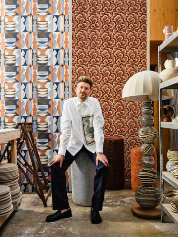 henry holland stood by lamp surrounded by his wallpaper