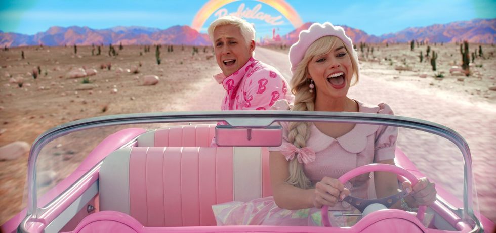 a person and a child in a pink car in a desert