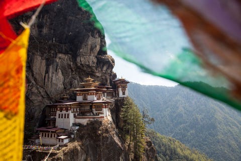 Paro Taktshang BhutanParo Taktshang in de Parovallei in Bhutan is een tempel die tegen de rotsen is gebouwd De tempel is alleen te bereiken via een steil voetpad langs watervallen gebedsmolens en een Tibetaans theehuis met schitterend uitzicht Volgens de overlevering heeft Padmasambhava de goeroe die het boeddhisme in Bhutan heeft gentroduceerd drie jaar in de grotten van Paro Taktshang gemediteerd nadat hij daar op de rug van een magische vrouwelijke tijger naartoe was gevlogen Vandaar de bijnaam Tijgersnest