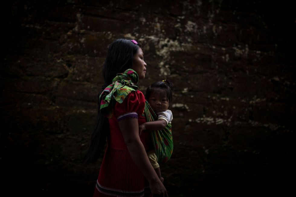 Maria an adolescent mother walks with her child whose father has disappeared
