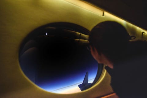 Aan boord van het vliegtuig dat het traject van de kernschaduw van de eclips volgt fotografeert Tafreshi een passagier die de vage buitenste schil van de zonneatmosfeer  de corona  bewondert