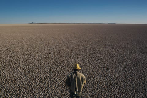 Op de hoogvlakte van Bolivia controleert een man de uitgedroogde resten van wat ooit het op n na grootste meer van het land was het Poopmeer Als gevolg van droogte en wateronttrekking is het meer opgedroogd