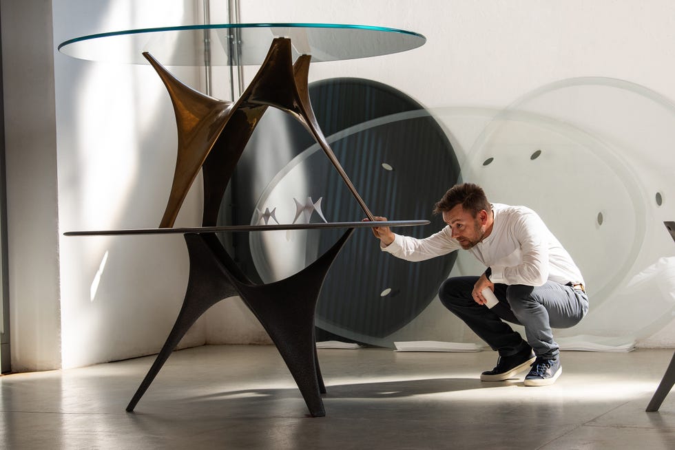 a man kneeling next to a sculpture