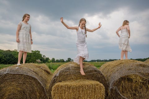 https://www.nationalgeographic.com/content/dam/photography/rights-exempt/most-moving-photos-2017/05-moving-2017-changinggirlhood06.jpg Op een boerderij in Kentucky spelen Emma Langley 13 Camille McCay 10 en Emerald Shean 10 in een pauze tijdens een dagcursus voor moeders en dochters waar de meisjes in de aanloop naar de puberteit hun lichaam leren kennen en waarderen