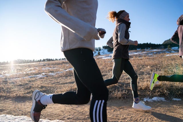 group of runners on a dirt path in a natural setting