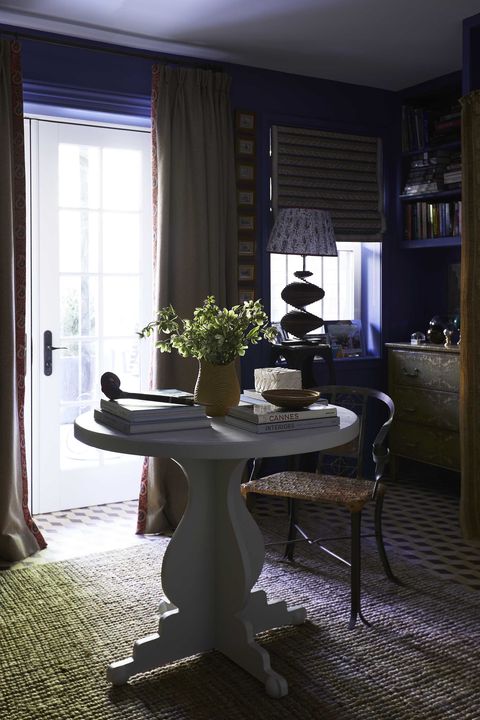 blue sitting room, blue painted wall, white circular table, coffee table books