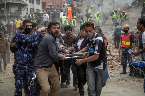 Niet alleen hulpverleners van de overheid droegen bij aan de reddingswerkzaamheden in de eerste uren na de aardbeving Deze arbeiders dragen een vrouw die gewond raakte bij de instorting van de historische Dharaharatoren in Kathmandu