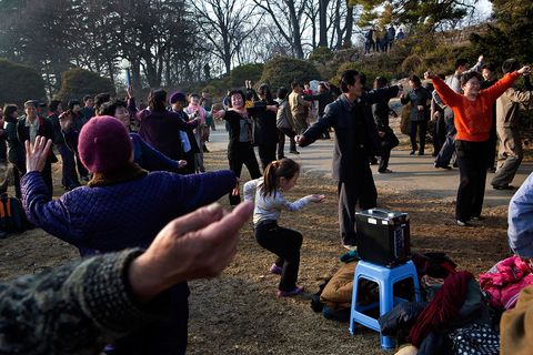 Een spreker draait populaire lokale muziek terwijl mensen van alle leeftijden samenkomen om te dansen in een park in Pyongyang