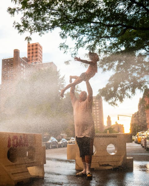 NEW YORK CITY VERENIGDE STATENEen vader en dochter maken creatief gebruik van een brandkraan om af te koelen tijdens een dag waarop de temperatuur oploopt tot boven de 40 graden in New York Dit doet me denken aan de zomers in Dhaka als we met ons gezin tijdens de regen op het dak gingen staan aldus fotograaf Ismail Ferdous