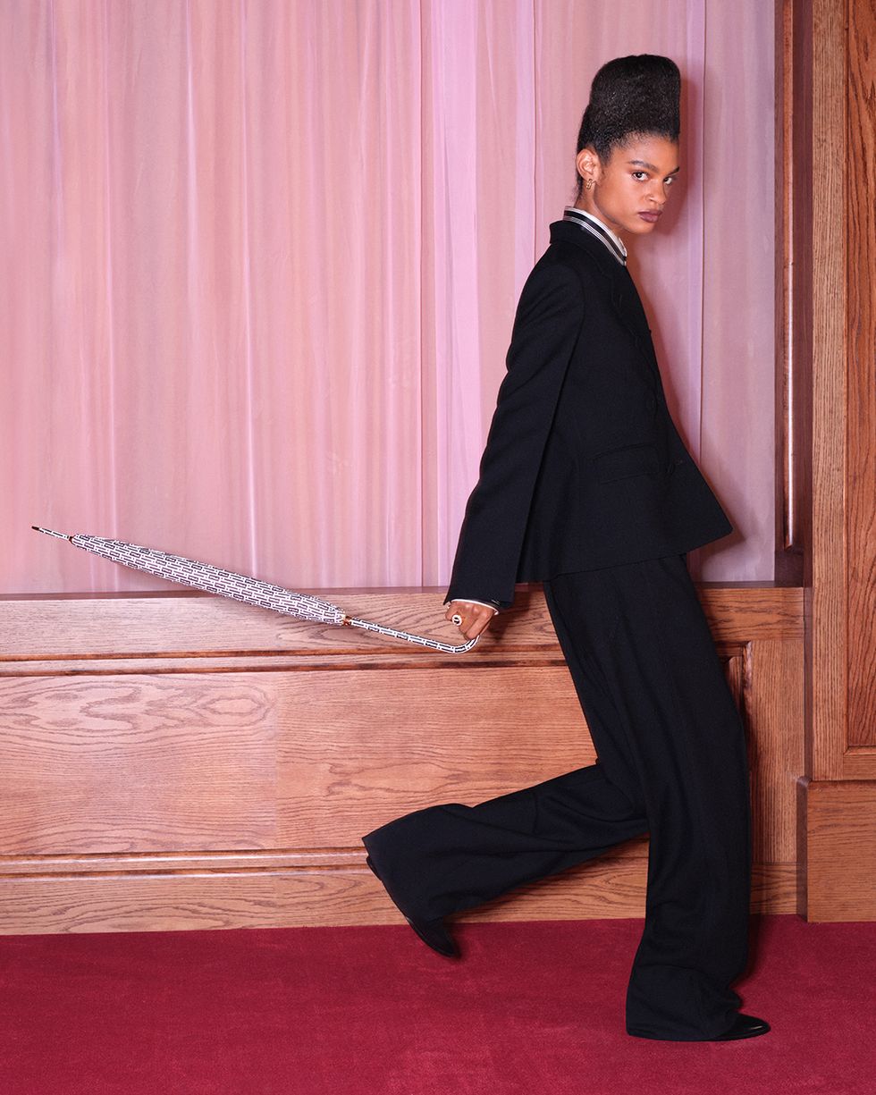 a person in a black suit holding a sword