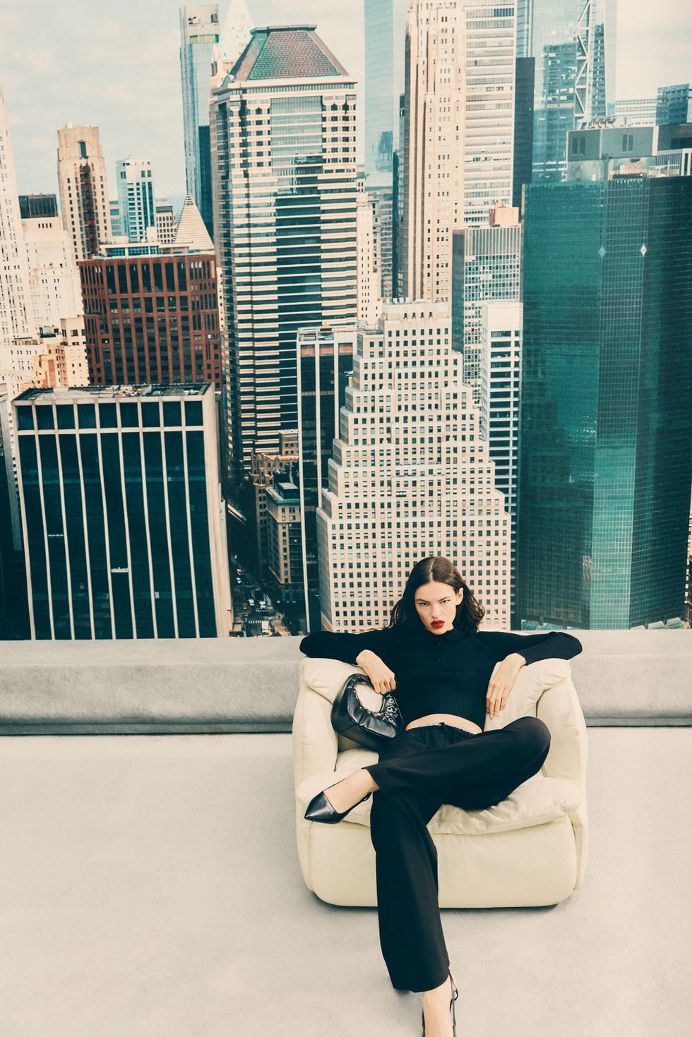 woman lounging in a modern urban setting with city skyline in the background