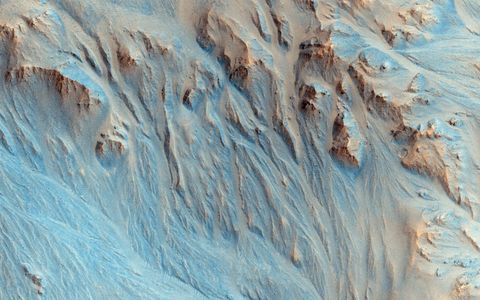 De NASAsonde Mars Reconnaissance Orbiter maakte deze opname van een verweerd landschap Geulen lopen naar beneden en monden uit in waaiers zoals die ook in de Mojavewoestijn zijn te zien waar ze worden afgezet door water dat uit diepe canyons in de bergen naar beneden stroomt