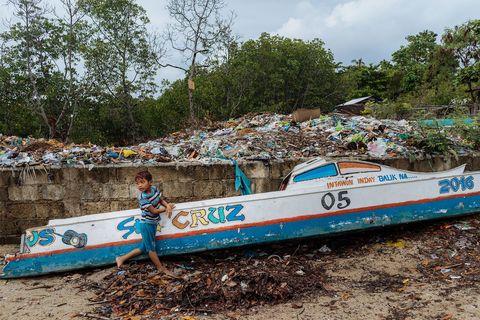 Een kind verkent een vuilnisbelt op het eiland Bohol