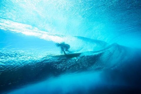 Een surfer berijdt een golf voor de kust van Teahupoo op het eiland Tahiti in FransPolynesi