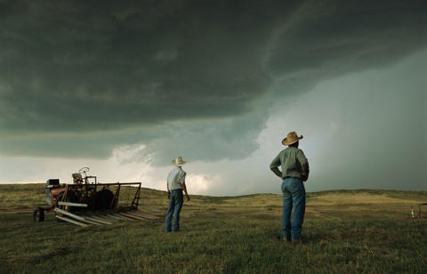 Boeren bekijken de groeiende stormwolken in de Sand Hills van Ogallala in Nebraska in 2003