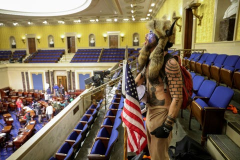 Een Trumpsupporter staat in de Senaatszaal terwijl Congresleden en hun medewerkers naar een veilige locatie worden afgevoerd