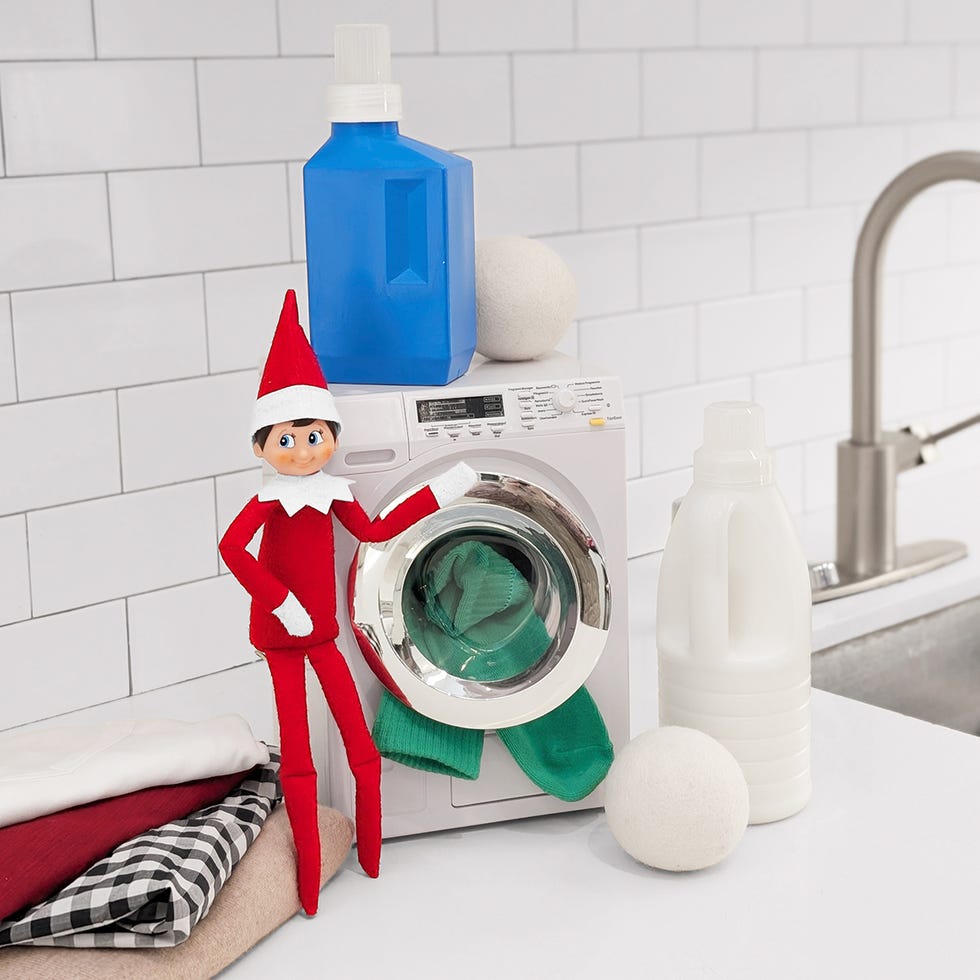 an elf on the shelf washes clothe using dollhouse appliances