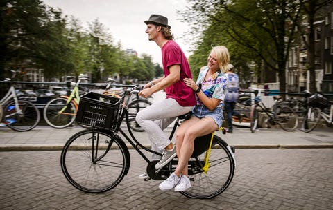 Een toerist volgt een rondleiding door Amsterdam met het fietsverhuurbedrijf Yellow Bike