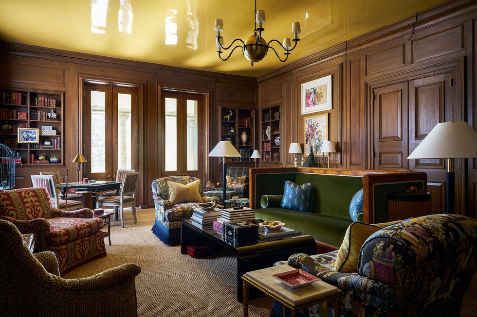 green sofa in brown wood paneled library