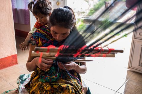 In haar huis is Erika Anglica Lpez Hernandez aan het weven met op haar rug haar dertienjarige dochter Brithany Erika liep stage bij de ACAM en studeerde af aan de Asociacin Corazn del Agua samen met de eerste jaargang van universitaire verloskundigen in Guatemala