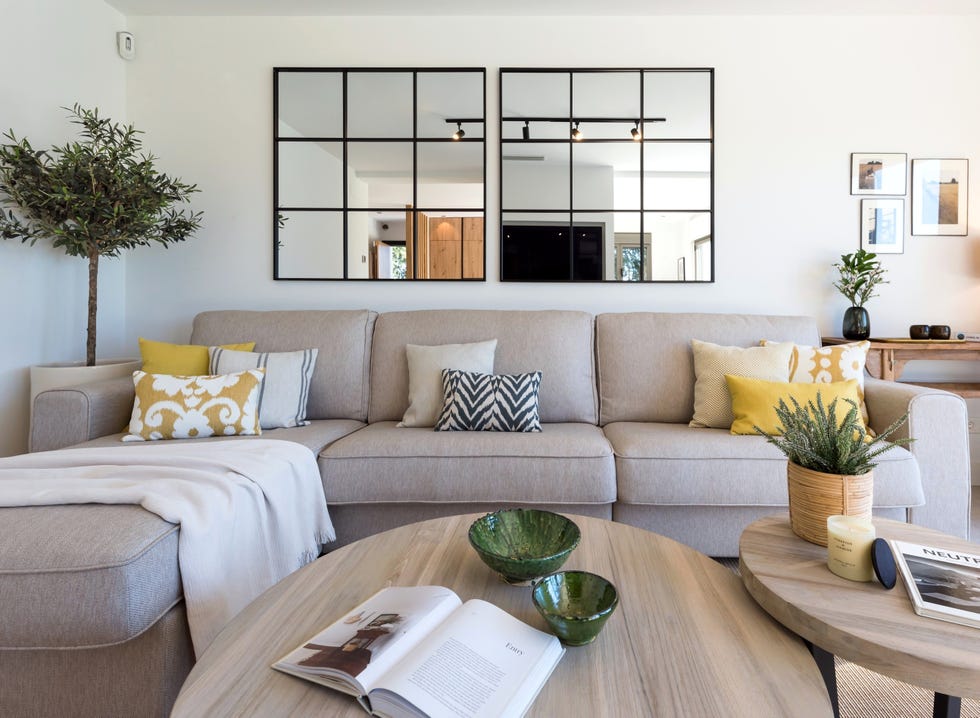 sofá gris con chaise longue y espejos tipo ventana