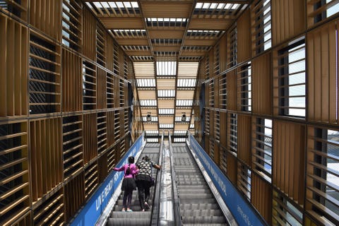 Bezoekers staan op de duizelingwekkende roltrap van de Nu Sentral mall inKuala Lumpur Dit winkelcentrum vol restaurants en zaken van grote merken ligt pal naast station Kuala Lumpur Sentral Het is een zo een handige plek voor een uitstapje voor zowel locals als bezoekers van de stad
