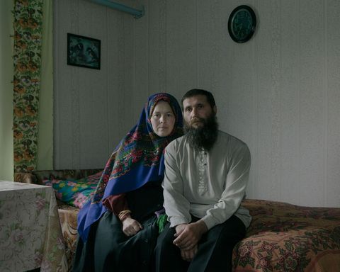 Antonina Borisova en Stepan Borisov zitten in traditionele gebedskleding in hun huis In Aidara is er geen kerk dus hebben de dorpelingen thuis vaak een speciaal ingewijde kamer waar zij en hun buren diensten kunnen houden