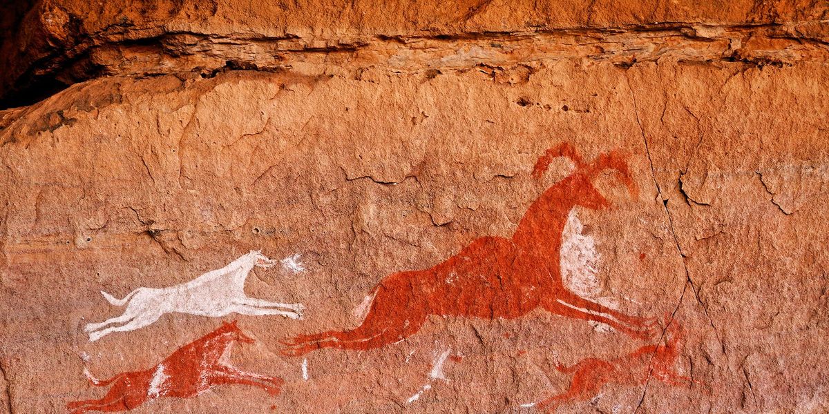 In deze 12000 jaar oude rotstekening in de bergachtige woestijn van Tadrart Acacus in Libi is uitgebeeld hoe een pak snelle honden een antilope opjaagt