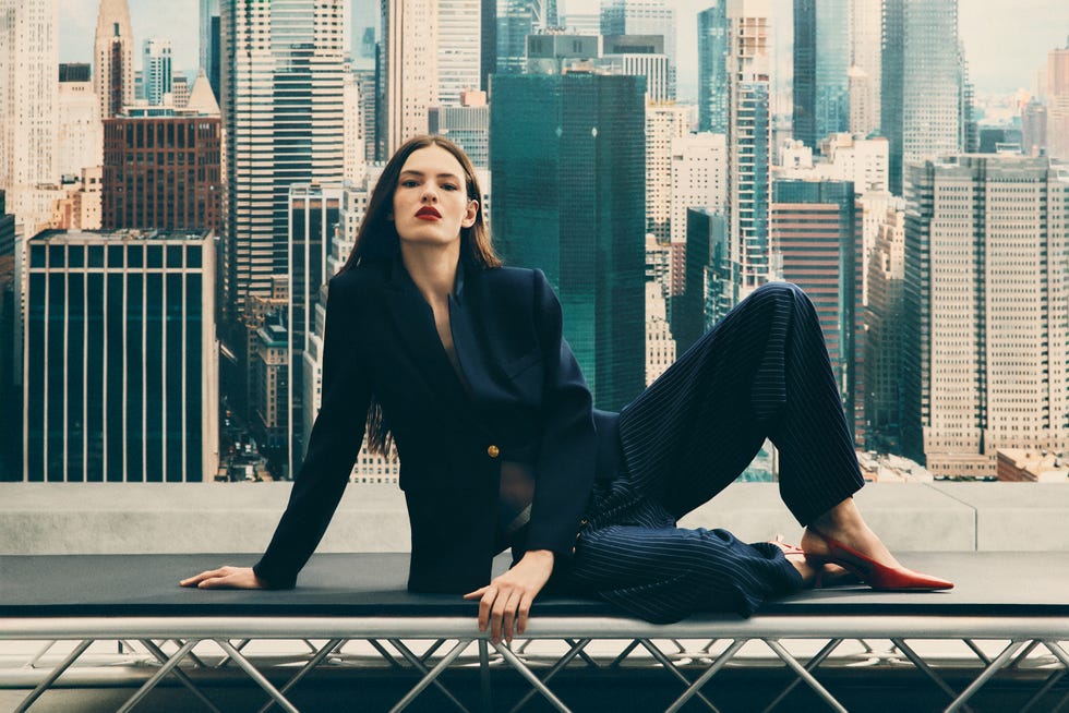 fashionable model poses against a city skyline