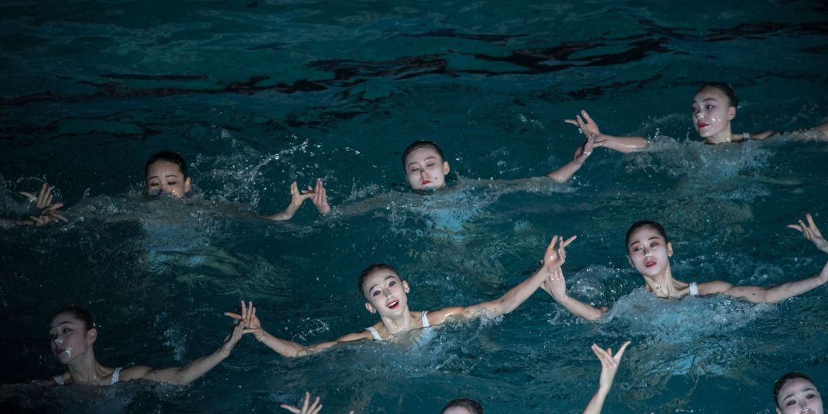Vrouwen voeren een synchroonzwemkuur uit als onderdeel van de feestelijkheden op de Dag van de Schijnende Ster