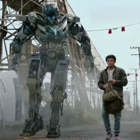 Anthony Ramos mientras Ramon Díaz camina con un transformador en una escena de Transformers Rise of the Beasts