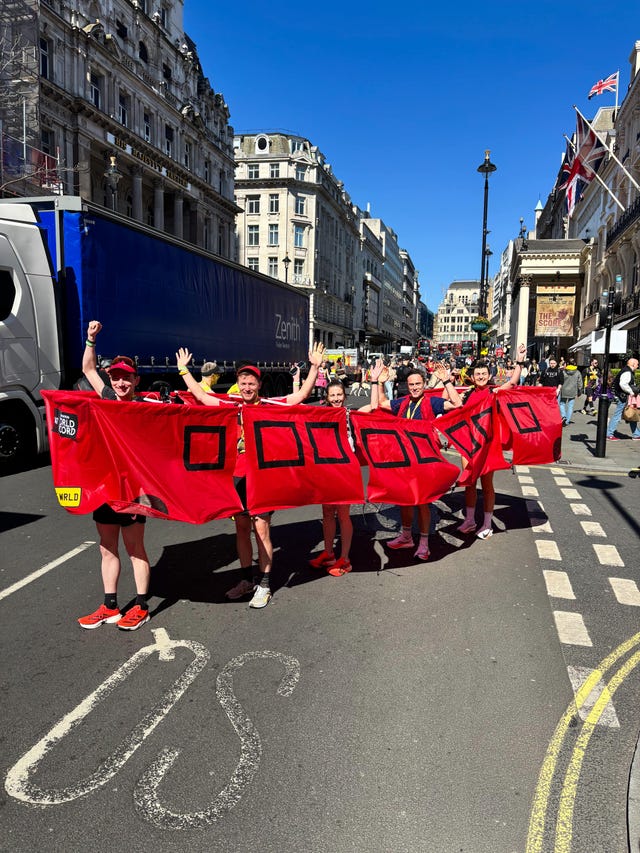group of five runners standing in a bus costume on a street in london