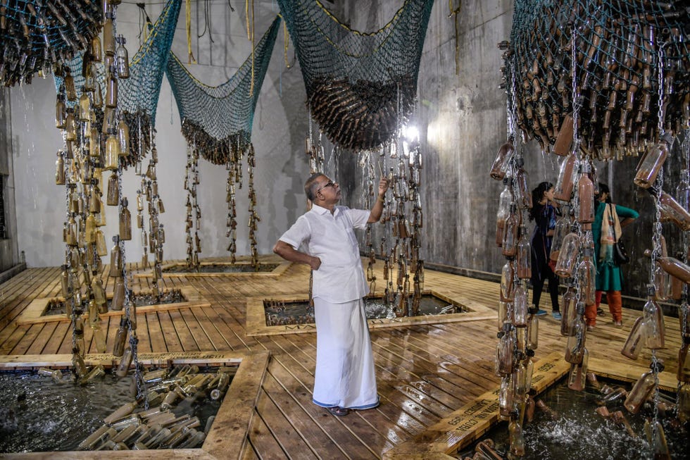 Bezoekers bekijken de installatie Messages from the Atlantic Passage van de ZuidAfrikaanse kunstenaar Sue Williamson op de KochiMuziris Biennale in Kochi India december 2018 De binnale is de grootste kunsttentoonstelling van ZuidAzi