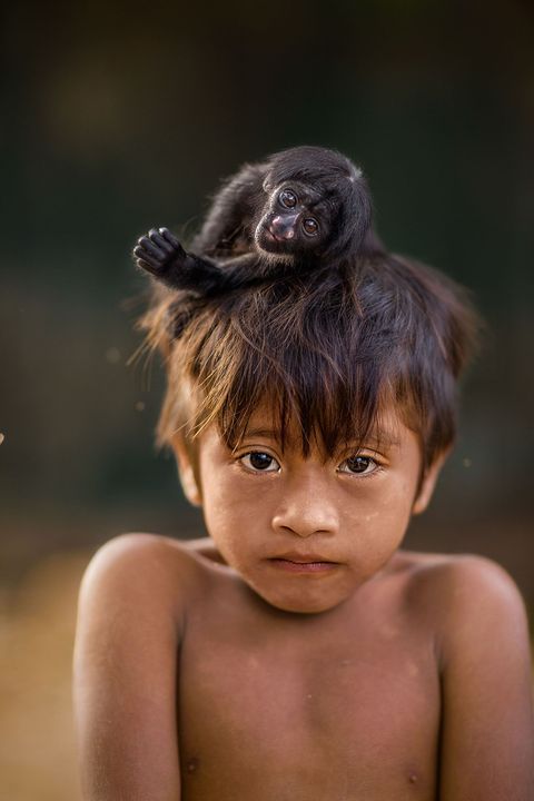 In het dorp Posto Aw in Brazili gaat Kaiau op de foto met een jonge baardsaki Het aapje is waarschijnlijk van een vrouwelijk gezinslid omdat jongens doorgaans geen apen als huisdier houden