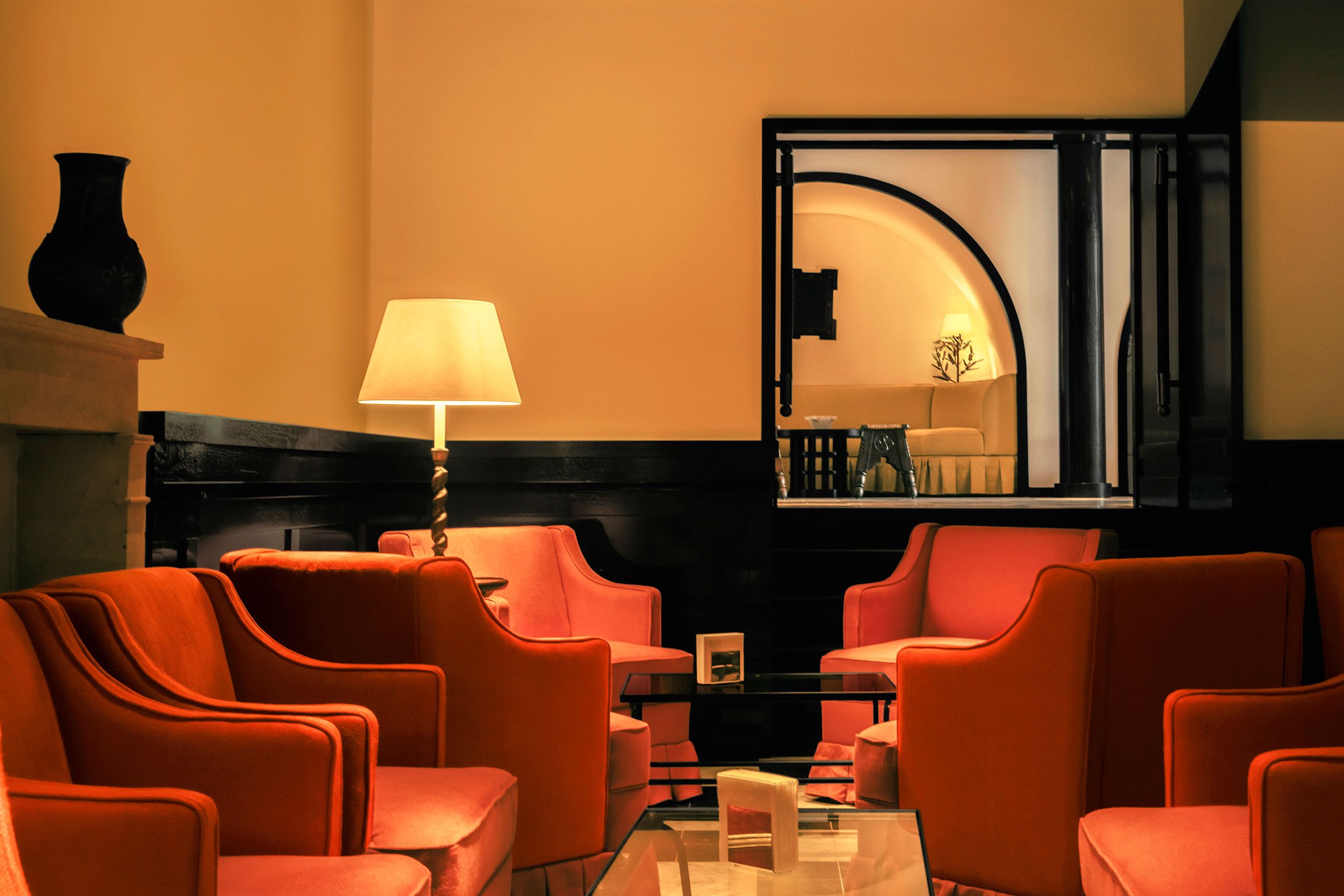 A List 2022 - ELLE DECOR bar area with red chairs and lamps and tables