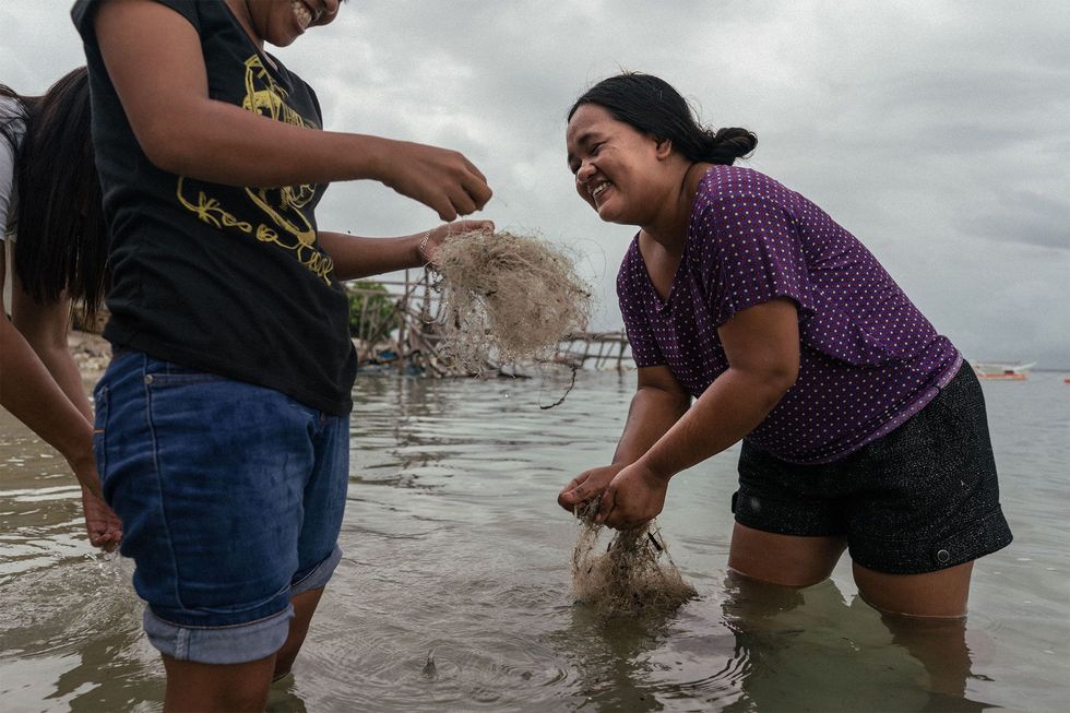 Filipijnse vrouwen maken afgedankte visnetten schoon De netten worden verkocht en in het buitenland gerecycled