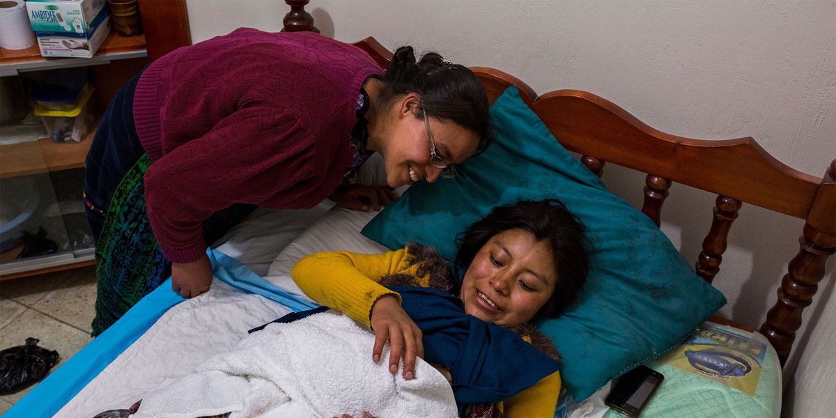 De kersverse moeder Gladys Sanchez Cabrera 18 en haar schoonzus Carolina bewonderen het nieuwste lid van hun familie Het kind werd s ochtends om 410 uur geboren in het kraamcentrum van de Asociacin de las Comadronas del Area Mam ACAM in het westelijke hoogland van Guatemala