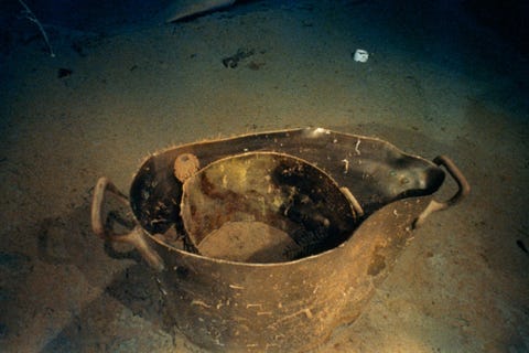Metalen kookpotten en een mok met het embleem van de White Star Line liggen in het puinveld van de Titanic