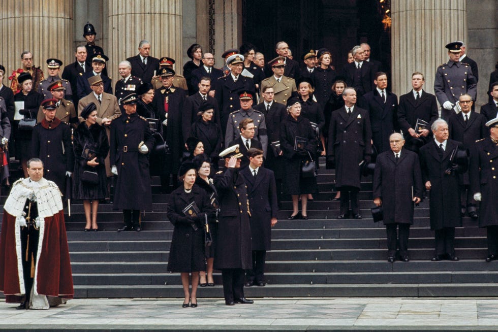 Winston Churrchill funeral Tijdens de staatsbegrafenis van expremier Winston Churchill in 1965 staat koningin Elizabeth II voor de trappen van SaintPauls Cathedral terwijl de kist met de voormalige staatsman vertrekt