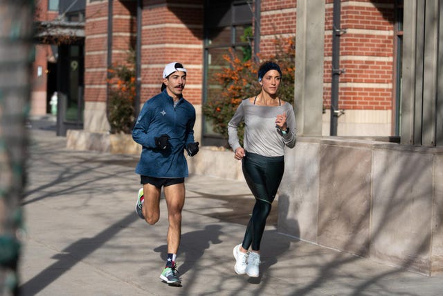 two individuals running outdoors on a sunny day