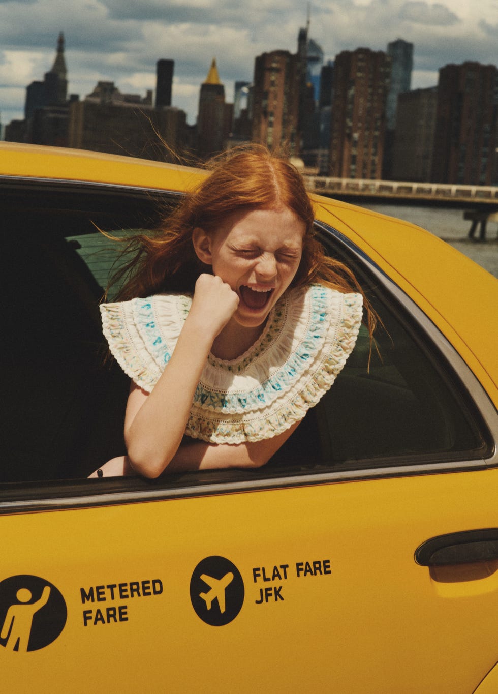 a person sticking the tongue out in a yellow car