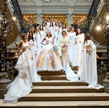 a group of women in white dresses on stairs