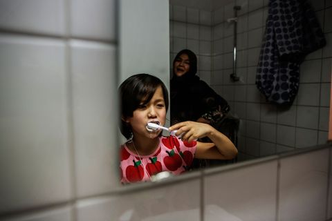 Masome Hasani poetst hier haar tanden ze kwam met haar familie vanuit Afghanistan naar Riksgrnsen Haar moeder staat achter haar