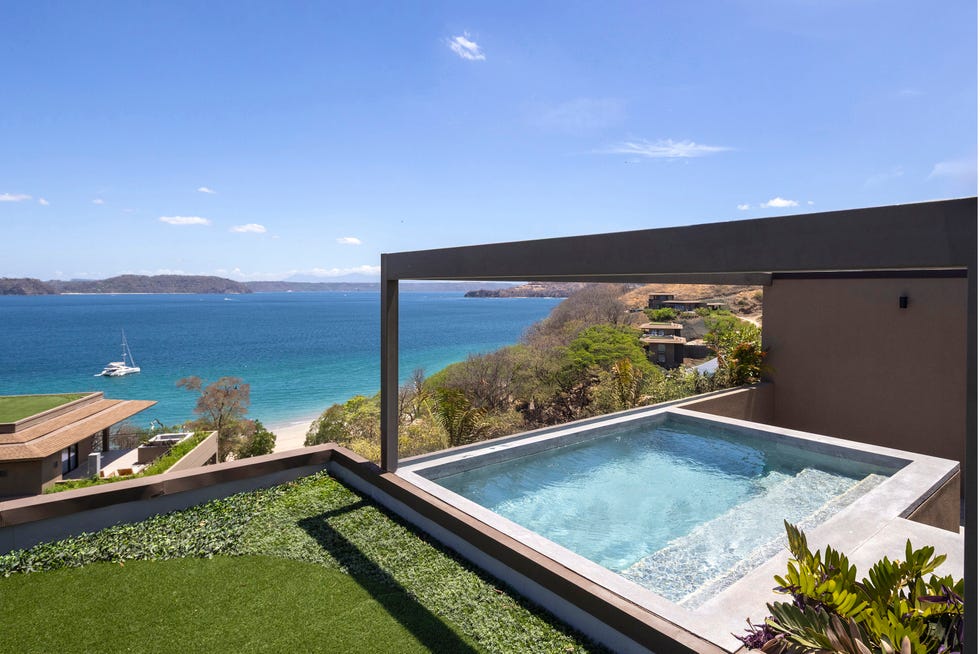 Luxury villa with a private pool overlooking a scenic beach.