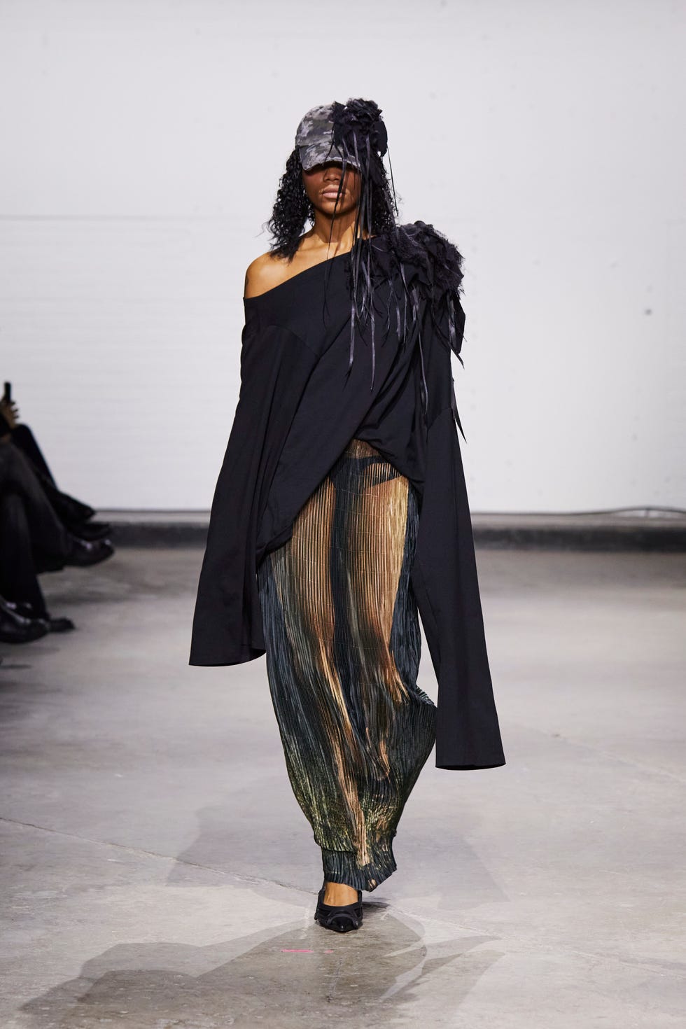 fashion show featuring a model in a striking outfit with a dramatic silhouette